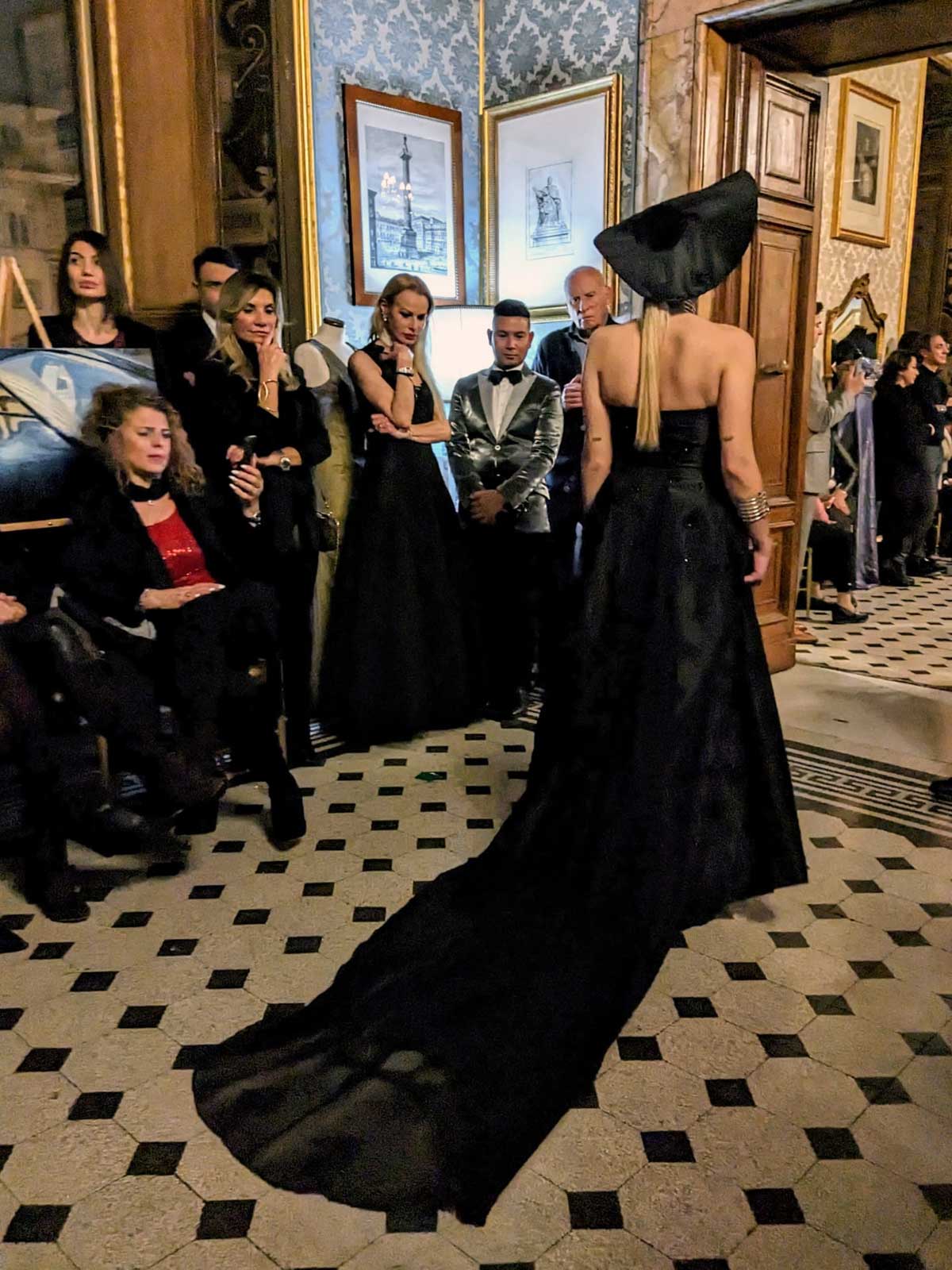 Mod’Art Roma - Il fascino dei colori - sfilata modelle nello storico Palazzo Ferrajoli - evento d’alta moda con gli eleganti abiti di Elins moda abito modella in nero elegante con cappello