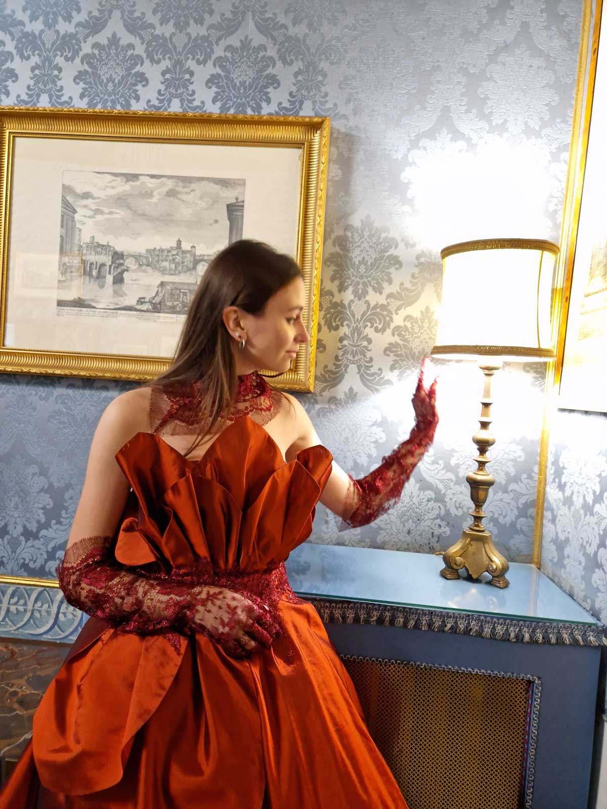 Mod’Art Roma - Il fascino dei colori - sfilata modelle nello storico Palazzo Ferrajoli - evento d’alta moda con gli eleganti abiti di Elins moda ragazza vestita in rosso bruno