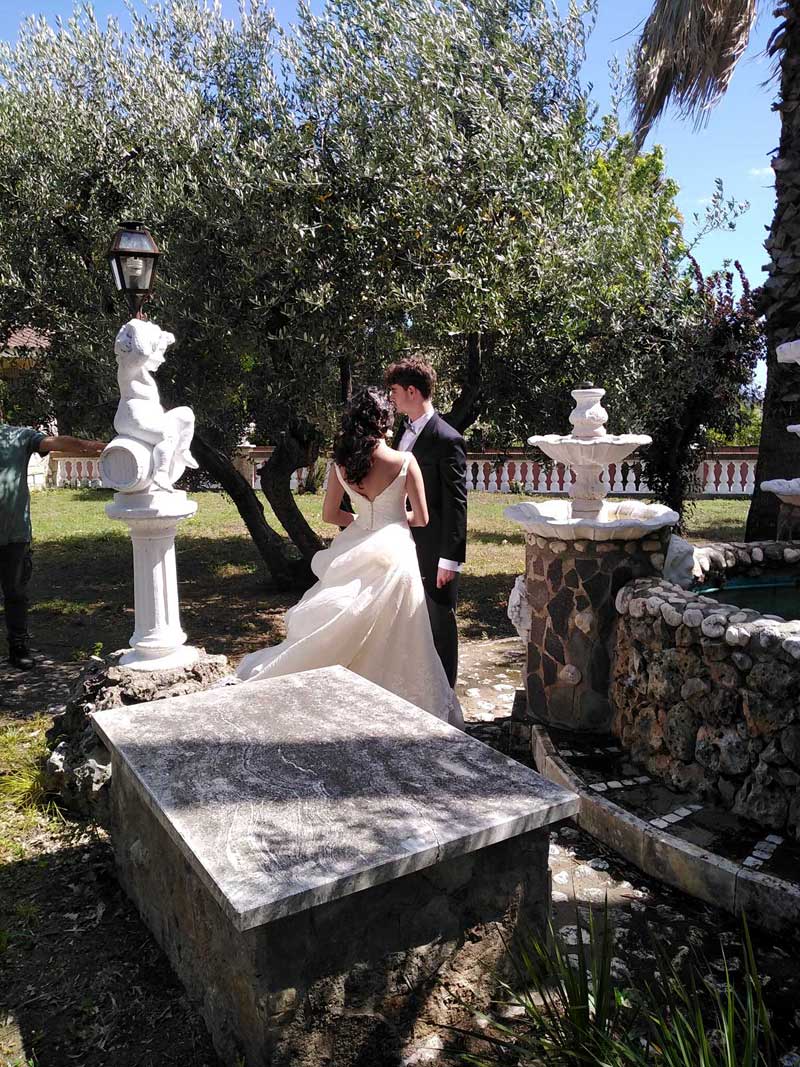 coppia sposi posano in giardino con fontana